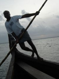 A boatman rows a traditional kettuvallam on Vembanad Lake.