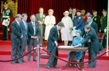 With Queen Elizabeth II's approval, the Charter was brought into effect in Ottawa on April 17, 1982. Trudeau stands front, second left to the Queen; Attorney General Jean Chrétien stands left to Trudeau.