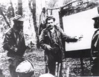 Guevara teaching guerrilla tactics to Congolese forces. His plan was to use the liberated zone on the western shores of Lake Tanganyika as a training ground for the Congolese and fighters from other liberation movements. To his left is Santiago Terry (codename: "Aly"), to his right, Angel Felipe Hernández ("Sitaini").