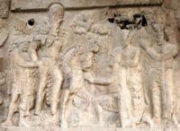 A rock relief at Naqsh-e Rostam. Behind Shapur, his hands clasped by the king's, stands the Emperor Valerian; kneeling before the king on one knee is Philip the Arab, and beneath the feet of the king's horse lies the body of Gordian III.