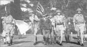 Lieutenant-General Percival led by a Japanese officer, marches under a flag of truce to negotiate the capitulation of Allied forces in Singapore, on 15 February 1942. It was the largest surrender of British-led forces in history.