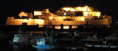 Castle Cornet seen at night over the boat harbour of St Peter Port