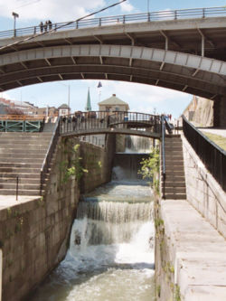 Original five step lock structure crossing the Niagara Escarpment at Lockport, now without gates and used as a cascade for excess water. A modern 40-foot-wide (12 meter) single-step lock is to the left, replacing another identical and original five-step lock.