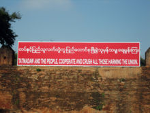 A government slogan at Mandalay Palace stating "Tatmadaw [Armed Forces] and the people, cooperate and crush all those harming the union."