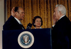 Vice President Ford is sworn in as the 38th President of the United States by Chief Justice Warren Burger; Betty Ford looks on.