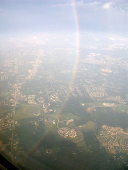 A portion of a 360 degree rainbow, seen from an aeroplane.