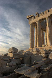 The Parthenon from the south. In the foreground of the image, a reconstruction of the marble imbrices and tegulae (roof tiles) forming the roof is visible, resting on wooden supports