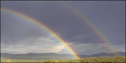 A double rainbow features reversed colours in the outer (secondary) bow, with the dark Alexander's band between the bows.