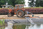 A farm tractor used to power a pump for irrigating a plot of land