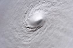 A picture of Hurricane Wilma's eye taken at 08:22 CDT (13:22 UTC) October 19, 2005, by the crew aboard the International Space Station. At the time, Wilma was the strongest Atlantic hurricane in history, with a minimum central pressure of only 882�mbar (26.06�inHg). Not only is this a classic example of a pinhole eye, but also of the stadium effect, where the eyewall slopes out and up.