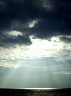 Sunlight shining through clouds in Dunstanburgh, England.