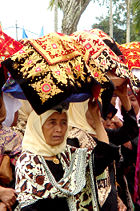 Minangkabau women carrying platters of food to a ceremony