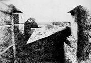 Nic�phore Ni�pce's earliest surviving photograph, c. 1826. This image required an eight-hour exposure, which resulted in sunlight being visible on both sides of the buildings.