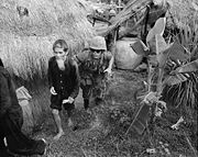 A Marine from 1st Battalion, 3rd Marines, moves an alleged NLF activist to the rear during a search and clear operation held by the battalion 15�miles (24�km) west of Da Nang Air Base.