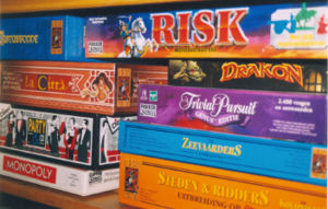 A shelf with several currently available board games. The left stack contains Carcassonne, La Citt�, Party & Co, and Monopoly. The right stack contains Risk, Drakon, Trivial Pursuit, The Seafarers of Catan, and Cities and Knights of Catan; some are of Dutch editions.