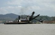 A bucket dredge works to deepen and widen the canal.