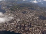 Downtown Seattle is bounded by Elliott Bay (lower left), lower Broadway (from upper left to lower right), Royal Brougham Way (lower right), and Denny Way (obscured by clouds).