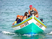 A wooden boat operating near shore.