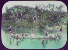 Solomon Island warriors with spears in ornamented war canoe