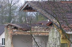 The structure of the house (under demolition). This house is constructred from bricks and wood and was later covered by insulating panels. The roof construction is also seen.