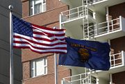 The flags of the United States and Oregon flown side-by-side in downtown Portland.