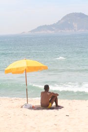 Man sitting under a beach parasol