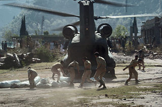 Pakistani Soldiers carry tents away from a U.S. Army CH-47 Chinook helicopter here October 19. The United States took part in the multinational effort to provide humanitarian assistance and support to Pakistan and Afghanistan following the devastating October 8 earthquake.