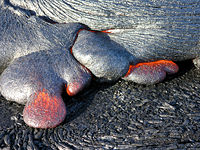 Pāhoehoe lava from Kīlauea flowing through a tube system down Pulama Pali, Hawaii, United States.