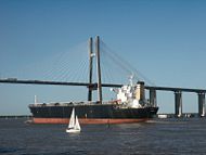 A cargo ship in front of the Rosario-Victoria Bridge.