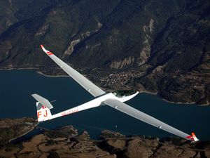 A single-seat high performance fiberglass Glaser-Dirks DG-808 over the Lac de Serre Pon�on in the French Alps