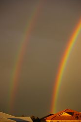 A double rainbow features reversed colours in the outer (secondary) bow, with the dark Alexander's band between the bows.