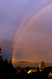 Primary and reflection rainbow at sunset