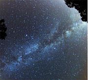 A green and red Perseid meteor is striking the sky just below the Milky Way in August 2007.