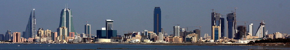 A panoramic view of the combined skylines of Manama and Seef. From left to right:1. The twin towers of the Bahrain WTC.2. The twin towers of the Bahrain Financial Harbor (BFH).3. The NBB tower (short building next to BFH).4. The Almoayyed Tower (tallest in the photo, center of image).5. The Abraj Al Lulu residential project (three towers) under-construction on the far-right).