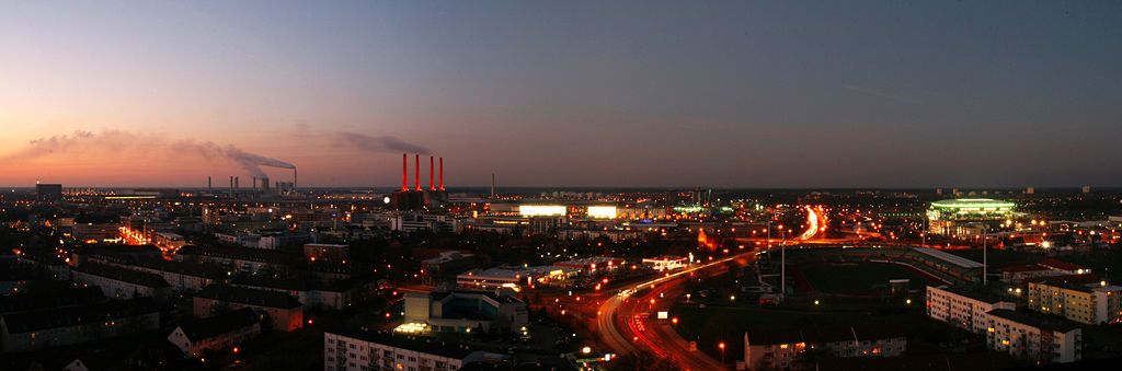 Wolfsburg panorama at dusk, viewed from Schillerteich-Center. The red-lit chimneys left of the center belong to the Volkswagen plant.