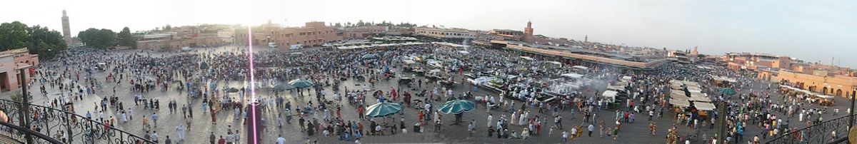 Panoramic picture of the Djemaa el Fna square at sunset. Koutoubia Mosque appears on the extreme left. The souks are in the alleys behind the square