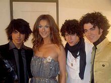 The Jonas Brothers surround singer Celine Dion