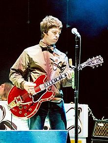 Noel Gallagher performing at a concert.