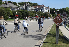 Bikers on M-185 (Main Street) at mile marker 0 in downtown Mackinac Island