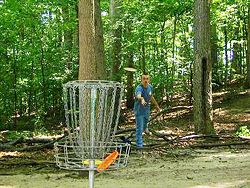 A player putting at Cass Benton Disc Golf Course, Northville, Michigan.