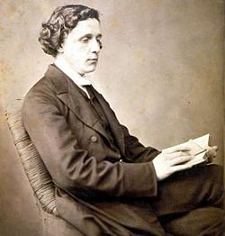 tinted monochrome 3/4-length photo portrait of seated Dodgson holding a book