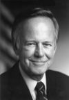 Black and white photo of a man in a suit smiling