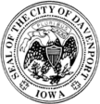 A circular seal with the text "Seal of the City of Davenport" and "Iowa" around the edge. An eagle is in the middle.