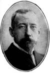 Head of a short-haired man with dark beard, looking staight to camera