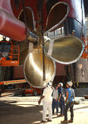 Shipyard employees reattaching the bronze propeller of Washington while in dry dock