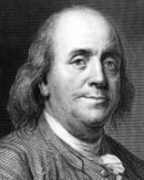 A seated older Benjamin Franklin from the waist up, with body facing to viewer's right but head turned toward the artist. Franklin's waistcoat is bulging a bit, his expression is inscrutable, and his hair hangs down to his shoulders.