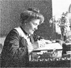 an older woman at a writing desk; she is shown in profile from her right and is writing on the desk