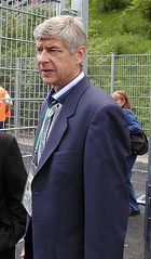 A grey-haired man in a blue suit, looking to the left