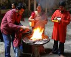 An Indian family performing a religious ritual over a fire.