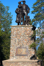 Three figures on a tall stone plinth.